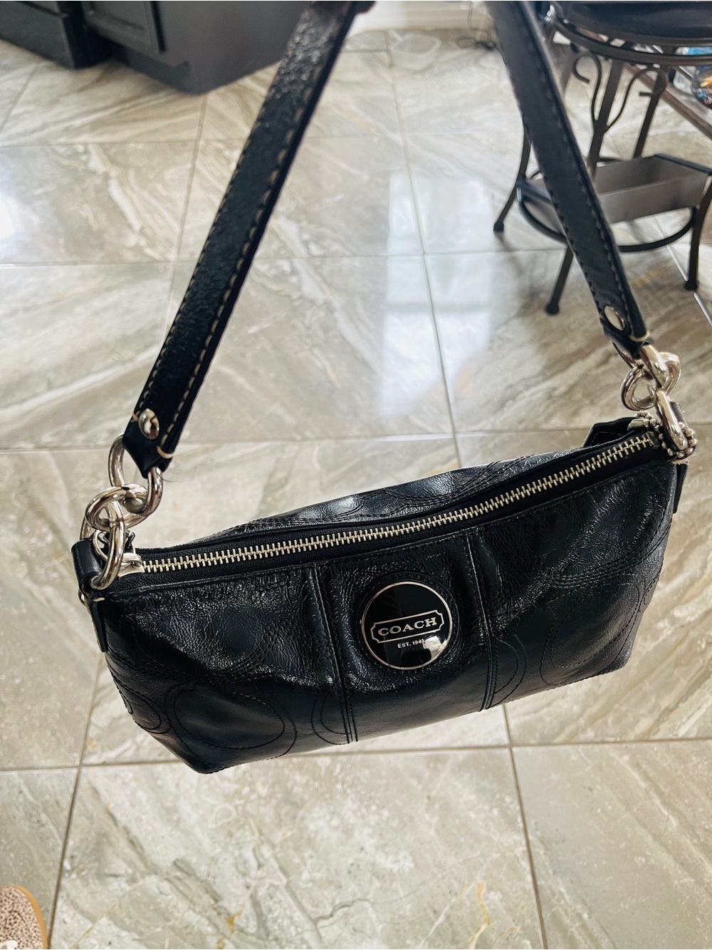 Coach black patent leather shoulder bag featuring an embossed Signatur